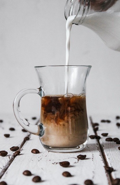 pouring cream into cofee