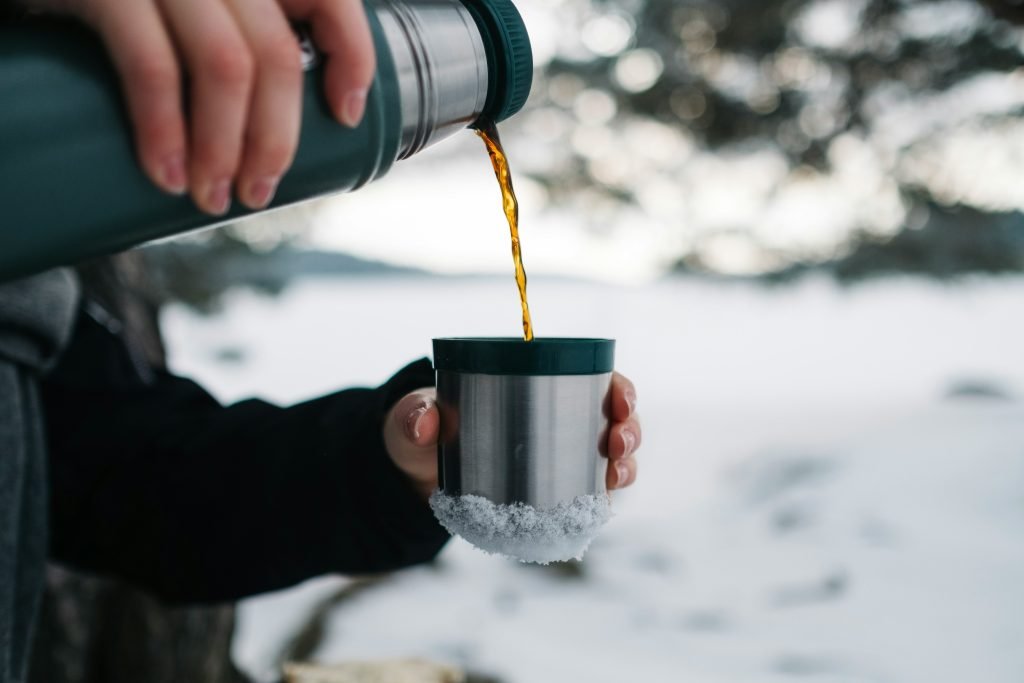 pouring coffee for hunters in snowy weather